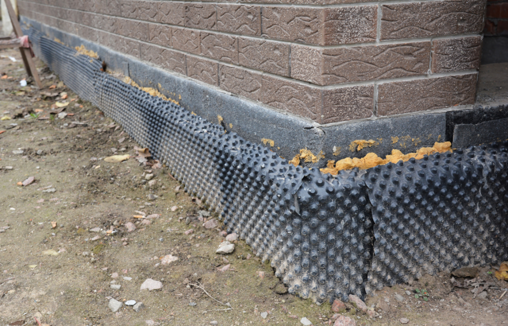 Foundation insulation with water proofing and damp proofing in problem corner area. House basement, foundation insulation details with waterproofing membrane